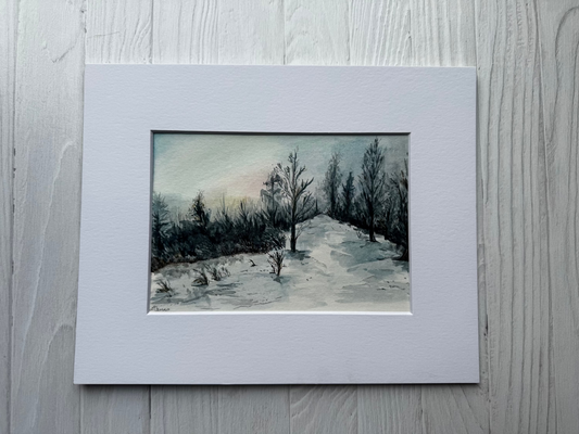 Matted watercolor artwork of a landscape with trees on a textured surface
